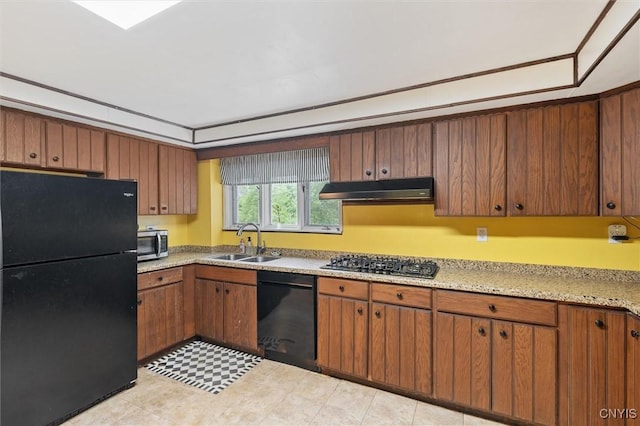 kitchen with black appliances, a sink, under cabinet range hood, and brown cabinetry