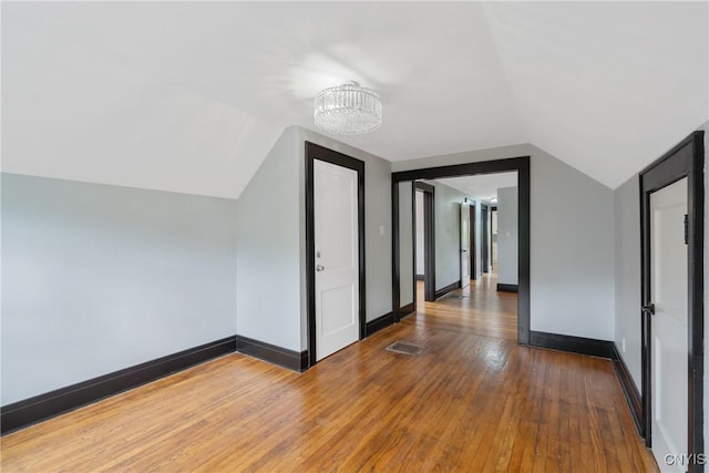944 Bellevue Ave, Syracuse, NY 13204 - bonus room with a chandelier, vaulted ceiling, hardwood / wood-style floors, and baseboards