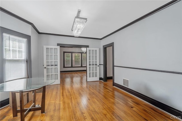 944 Bellevue Ave, Syracuse, NY 13204 - spare room with a chandelier, crown molding, light wood-type flooring, baseboards, and french doors