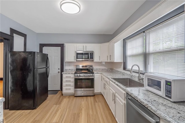 944 Bellevue Ave, Syracuse, NY 13204 - kitchen featuring stainless steel appliances, a sink, white cabinets, and light wood-style floors