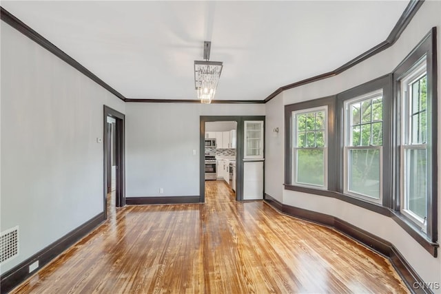 944 Bellevue Ave, Syracuse, NY 13204 - empty room with baseboards, crown molding, wood finished floors, healthy amount of natural light, and a chandelier