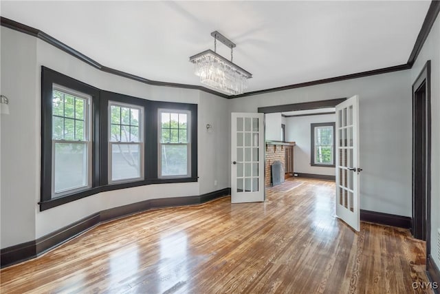 944 Bellevue Ave, Syracuse, NY 13204 - spare room featuring french doors, crown molding, wood finished floors, baseboards, and a chandelier