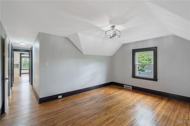 944 Bellevue Ave, Syracuse, NY 13204 - bonus room with hardwood / wood-style floors, healthy amount of natural light, lofted ceiling, and baseboards