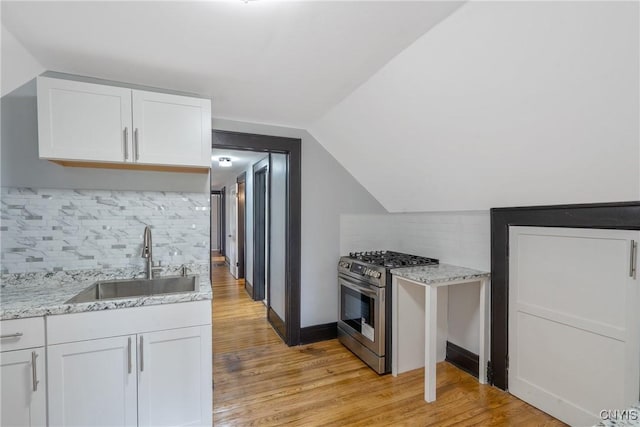 944 Bellevue Ave, Syracuse, NY 13204 - kitchen featuring stainless steel range with gas stovetop, a sink, white cabinets, backsplash, and light wood-type flooring