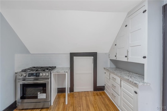944 Bellevue Ave, Syracuse, NY 13204 - kitchen with stainless steel gas range oven, vaulted ceiling, white cabinets, light wood finished floors, and light stone counters