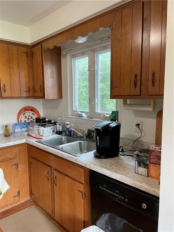 6088 Brockport Spencerport Rd Unit 2, Sweden, NY 14420 - kitchen with dishwasher, a sink, light countertops, and brown cabinetry