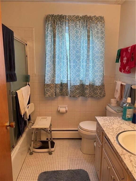 6088 Brockport Spencerport Rd Unit 2, Sweden, NY 14420 - full bathroom with tile walls, tile patterned flooring, toilet, combined bath / shower with glass door, and vanity