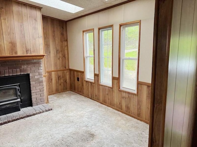 178 Dunshee Rd, Sidney, NY 13849 - unfurnished living room featuring wooden walls, a skylight, carpet, a textured ceiling, and wainscoting