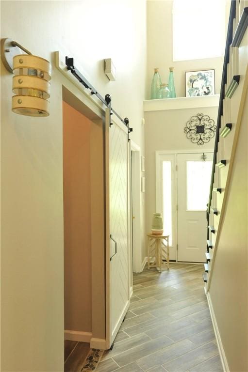 90 Davenport Rd, Big Flats, NY 14814 - doorway to outside featuring a barn door, light wood-style floors, stairs, and baseboards
