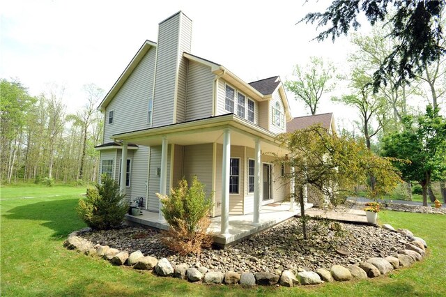90 Davenport Rd, Big Flats, NY 14814 - view of side of property with a yard, a chimney, and a porch