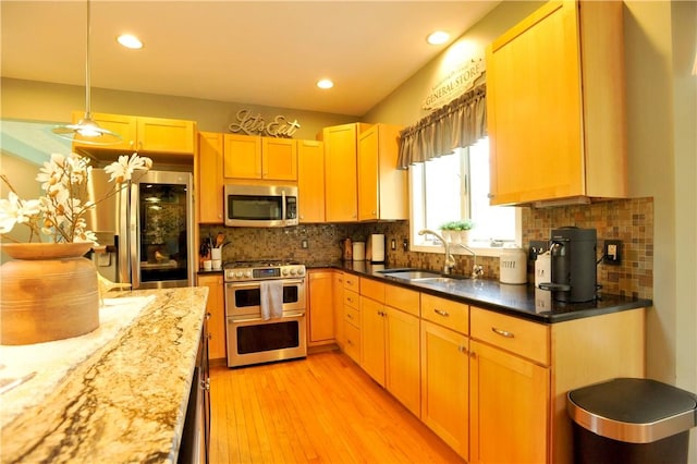 90 Davenport Rd, Big Flats, NY 14814 - kitchen featuring stainless steel appliances, a sink, backsplash, light wood-type flooring, and dark stone counters