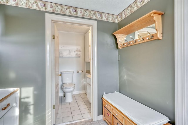4231 Cauwels Rd, Arcadia, NY 14505 - bathroom featuring toilet, tile patterned flooring, a textured ceiling, and baseboards