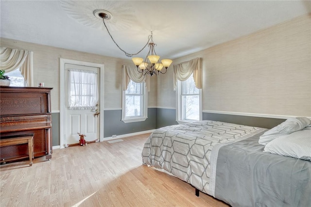 4231 Cauwels Rd, Arcadia, NY 14505 - bedroom with a chandelier, wood finished floors, wallpapered walls, baseboards, and a wainscoted wall