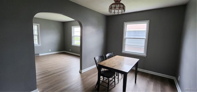 925 Calvert St, Rome-Inside, NY 13440 - dining space featuring arched walkways, wood finished floors, and baseboards