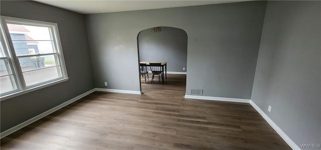 925 Calvert St, Rome-Inside, NY 13440 - empty room featuring arched walkways, wood finished floors, and baseboards