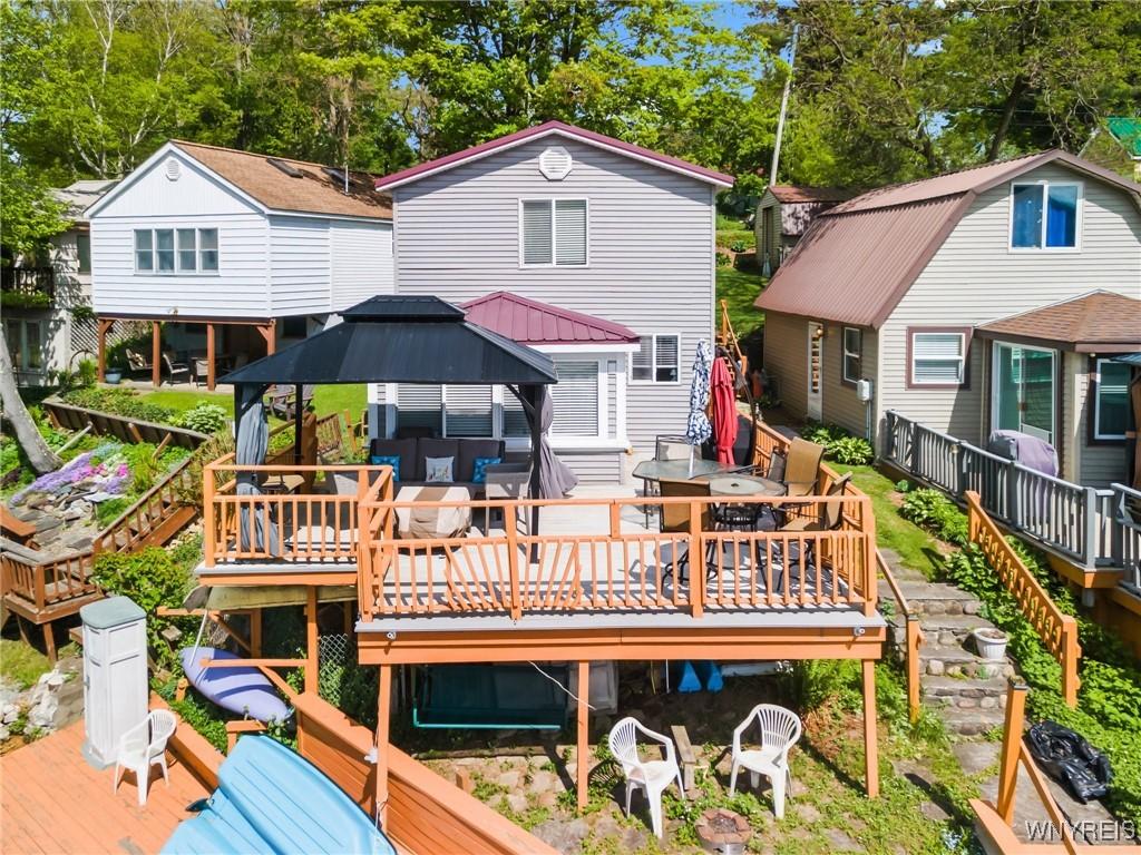 328 Lakeview Blvd, Machias, NY 14042 - rear view of house featuring a gazebo, outdoor dining area, a wooden deck, and view of wooded area