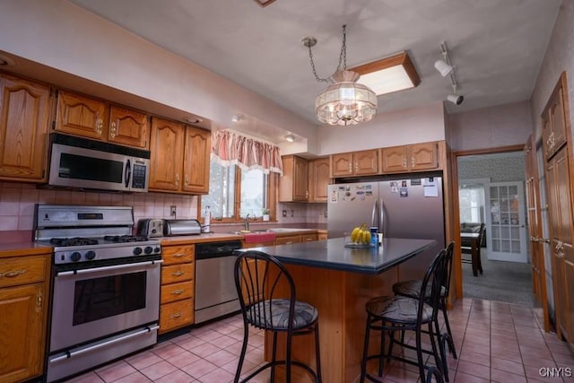 1628 Mohawk St, Utica, NY 13501 - kitchen with stainless steel appliances, light tile patterned floors, brown cabinets, a kitchen bar, and decorative backsplash