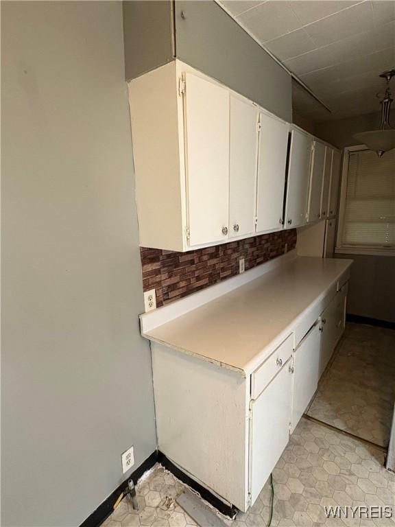 68 Decker St, Buffalo, NY 14215 - kitchen with backsplash, white cabinetry, and light countertops