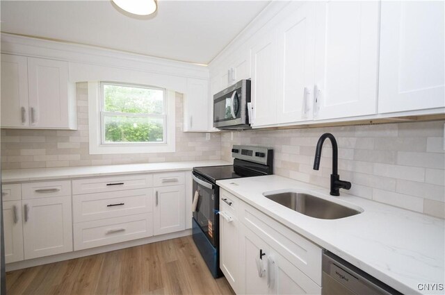 5646 Vistula, Cicero, NY 13029 - kitchen with appliances with stainless steel finishes, a sink, white cabinets, and tasteful backsplash