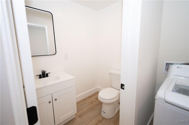 5646 Vistula, Cicero, NY 13029 - bathroom with washer / dryer, vanity, wood finished floors, toilet, and baseboards
