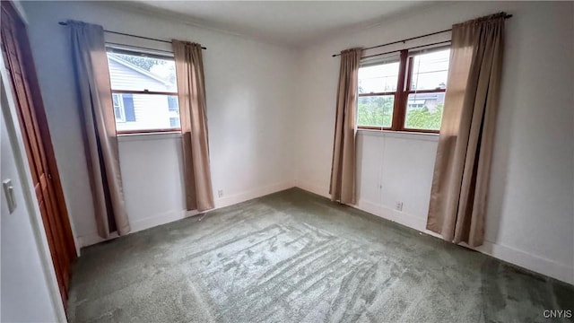 carpeted spare room with healthy amount of natural light and baseboards