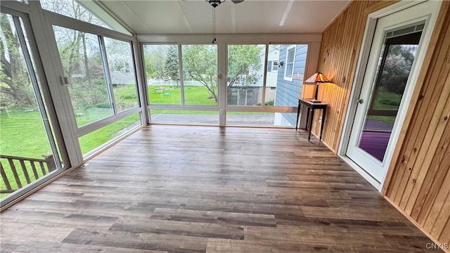unfurnished sunroom with wood finished floors and wooden walls