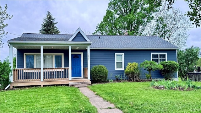view of front facade with a front lawn, a porch, and a shingled roof