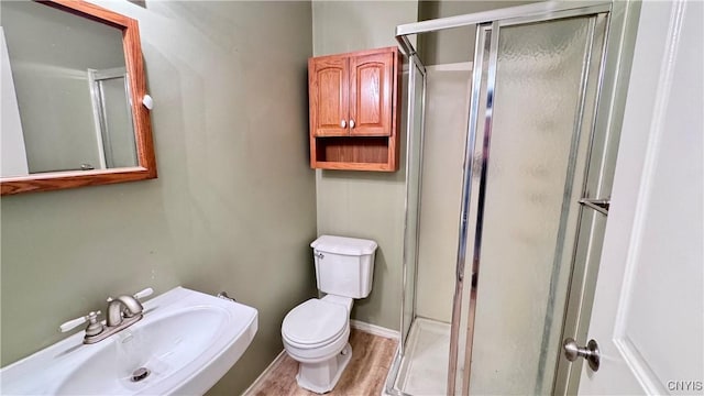 full bathroom featuring a sink, a stall shower, and toilet