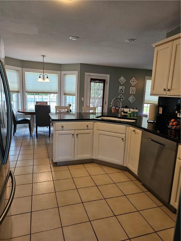 1 Woodsview Dr, Big Flats, NY 14903 - kitchen featuring a sink, a peninsula, dark countertops, freestanding refrigerator, and light tile patterned flooring
