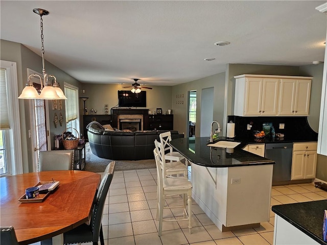 1 Woodsview Dr, Big Flats, NY 14903 - kitchen with dishwasher, a sink, a peninsula, ceiling fan, and dark countertops