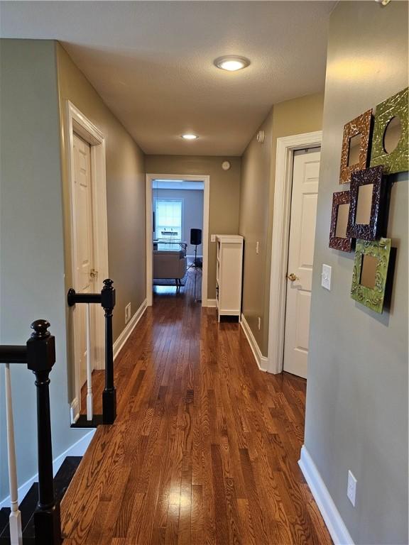 1 Woodsview Dr, Big Flats, NY 14903 - corridor featuring dark wood finished floors, baseboards, and an upstairs landing