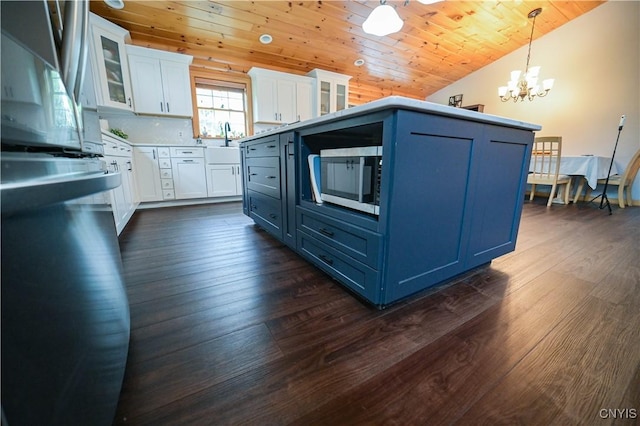 161 Mcclure Rd, Salisbury, NY 13470 - kitchen featuring fridge, a chandelier, stainless steel microwave, white cabinets, and dark wood-style flooring
