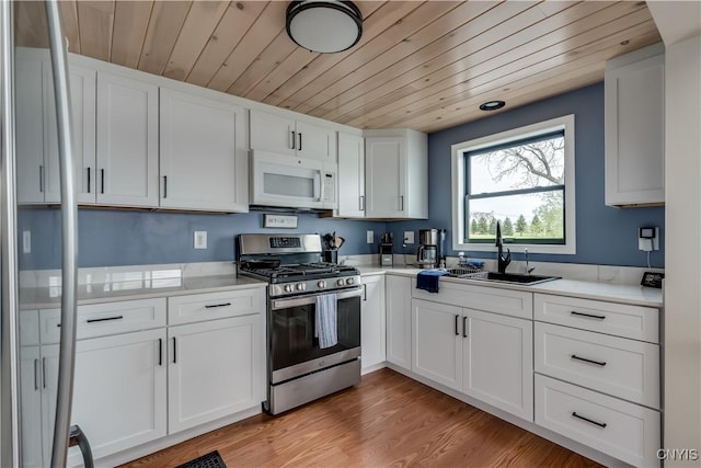 17695 County Route 59, Brownville, NY 13634 - kitchen featuring stainless steel range with gas cooktop, white microwave, a sink, wood ceiling, and light countertops