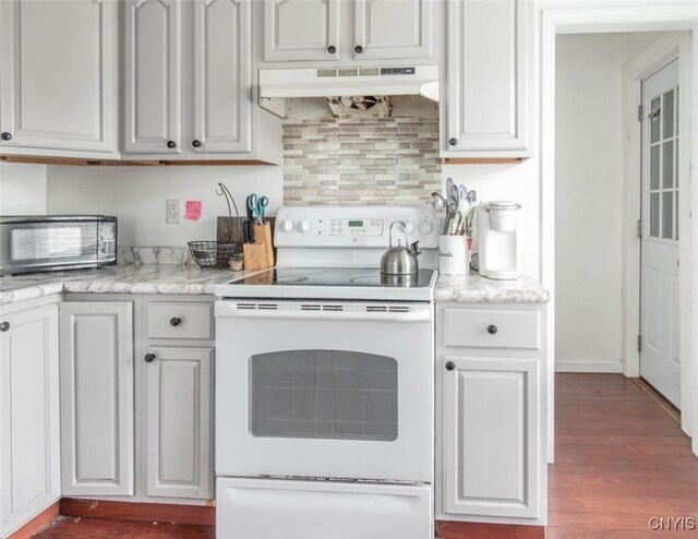 71 Champion St, Champion, NY 13619 - kitchen featuring electric stove, under cabinet range hood, dark wood-style flooring, and backsplash