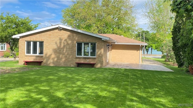 back of property with a yard, brick siding, and a patio area