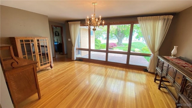 dining space with a chandelier and light wood-style floors