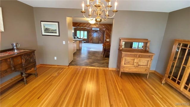 dining space featuring a chandelier, baseboards, and wood finished floors