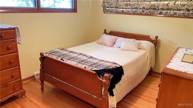 bedroom with light wood-style floors and baseboards