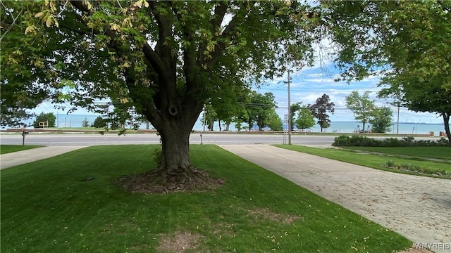 surrounding community with a lawn and a water view
