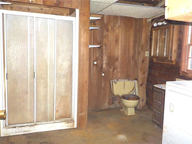 6900 White Rd, Conesus, NY 14435 - bathroom featuring wood walls, toilet, unfinished concrete flooring, and washer / dryer