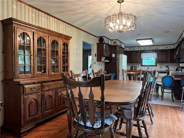 8584 Vieley Rd, Campbell, NY 14821 - dining space with crown molding, a chandelier, light wood-type flooring, and wallpapered walls