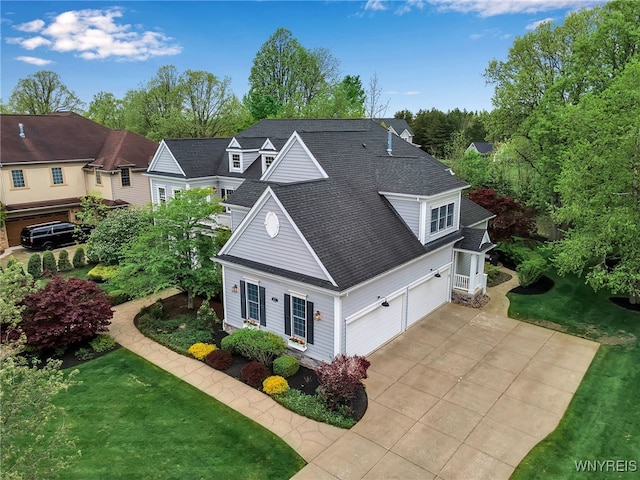view of home's exterior with concrete driveway, roof with shingles, an attached garage, and a yard