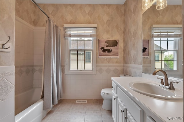 bathroom featuring tile patterned flooring, toilet, vanity, shower / bath combination with curtain, and wallpapered walls