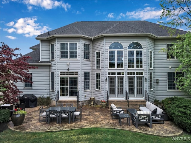 back of property featuring a patio area, an outdoor hangout area, entry steps, and roof with shingles