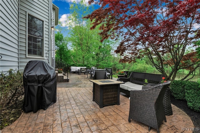 view of patio with an outdoor living space with a fire pit and a grill