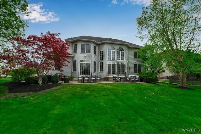 back of house with a patio area and a lawn