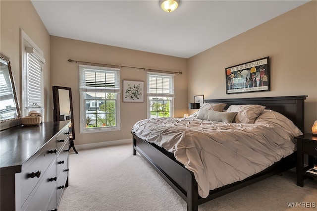 bedroom featuring light carpet and baseboards