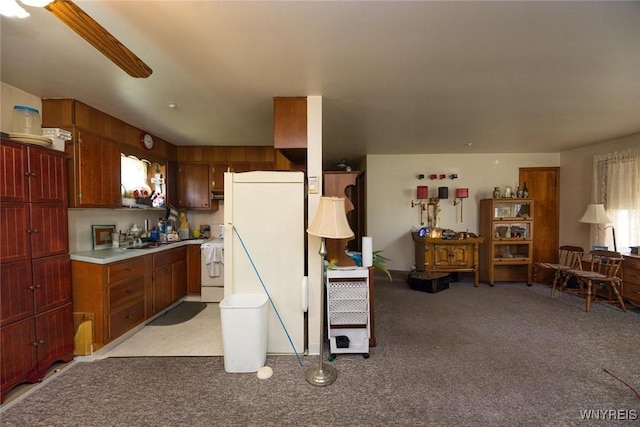 7233 Ridge Rd, Newfane, NY 14094 - kitchen with stove, light colored carpet, light countertops, a sink, and ceiling fan