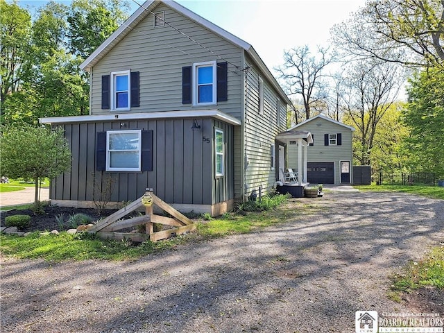 55 Washington Ave, Pomfret, NY 14063 - view of front facade with board and batten siding, a garage, and driveway