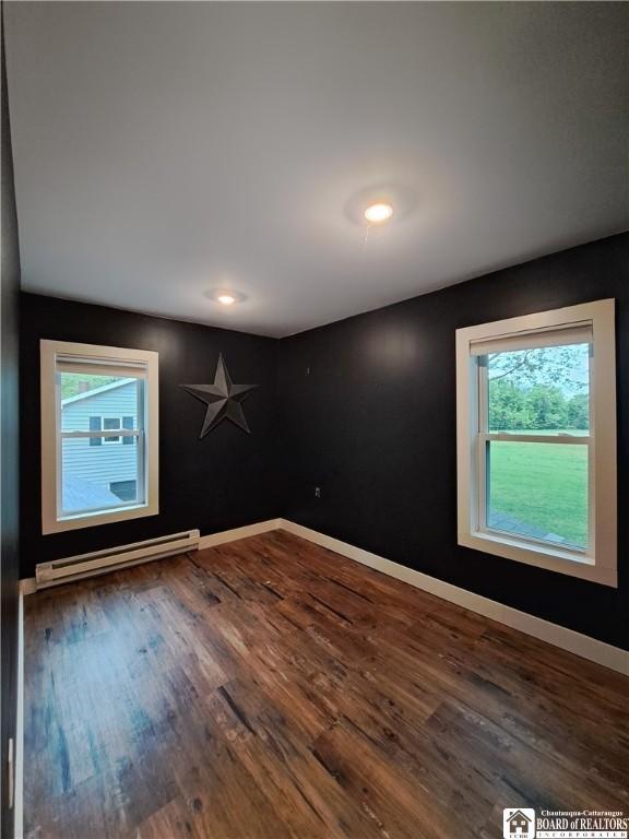 55 Washington Ave, Pomfret, NY 14063 - empty room featuring a baseboard radiator, healthy amount of natural light, and wood finished floors